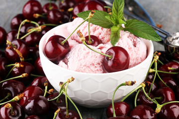 Homemade cherry ice cream and a bunch of cherries on table