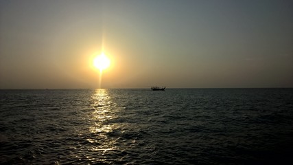sunset on the ocean with boat