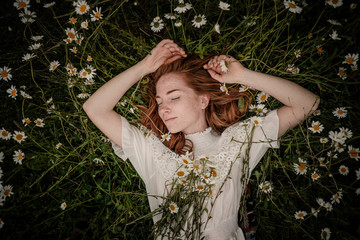 Beautiful woman enjoying daisy field, nice female lying down in meadow of flowers