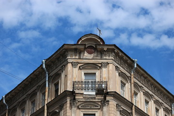 Fototapeta na wymiar Typical Petersburg house against the blue sky with clouds, Russia