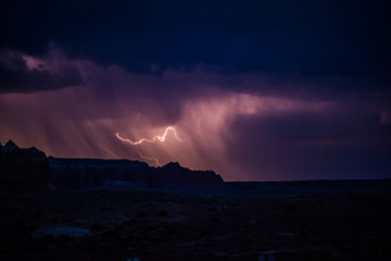 Night sky during the thunderstorm in the distance with canyons.