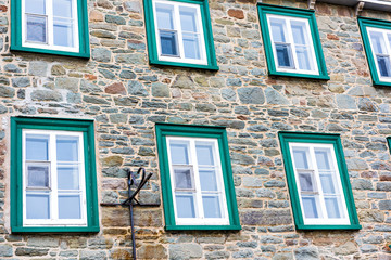 Closeup of european architecture stone building with green window frames