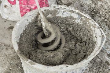 Concrete mixing with electrical drill and mixer. Wet Facade Insulation