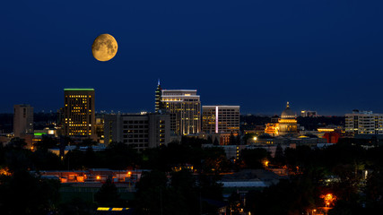Boise city at night with a large yellow moon over the skyline © knowlesgallery
