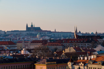 Fototapeta premium Prague cityscape with red tile roofs, St Vitus Cathedral and Hradcany Castle. Scenic spring sunset in town
