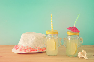 Image of fresh lemonade drink in cute cactus shape glasses over wooden table. Tropical summer romantic vacation concept.