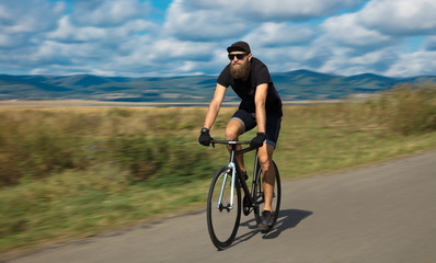 Naklejka na ściany i meble Natural view with cyclist going somewhere with stylish bike