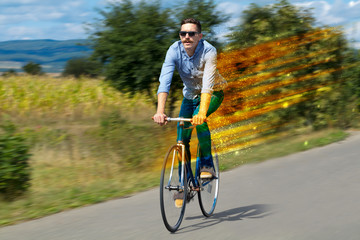 Obraz premium Young riding bicycle in fabulous nature with high speed