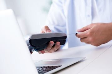 Man processing credit card transaction with POS terminal