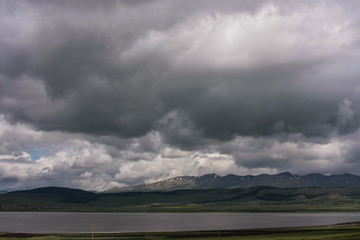 mountains, lake and stormy clouds