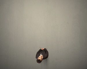 Young businessman contemplating a decision standing on a grey surface