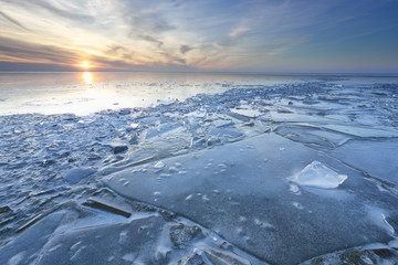 Fototapeta premium sunset over shelf ice on frozen lake