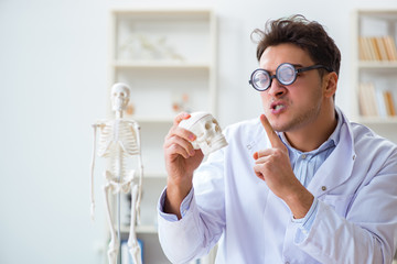 Crazy doctor studying human skeleton
