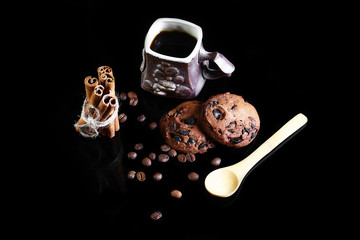 close-up cup of espresso coffee, spoon, round crunchy chocolate cookies with coffee beans, sticks...