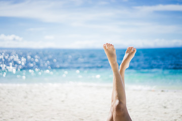 Feet of girl on the background of sea and sky. Girl at the resort. Female feet on sea background. Girl sunbathes on a beach. Meditation on the sea. Red pedicure.
