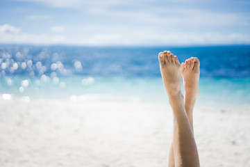 Feet of girl on the background of sea and sky. Girl at the resort. Female feet on sea background. Girl sunbathes on a beach. Meditation on the sea. Red pedicure.