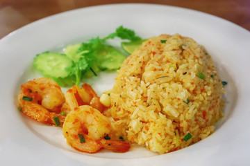 Fried Rice with Shrimp Paste in white dish on the wooden floor.