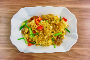 Fried Vermicelli in white dish on the wooden floor.