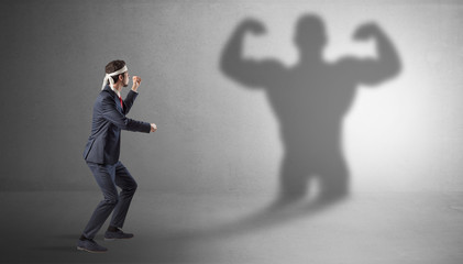 Businessman fighting with his bossy yelling shadow
