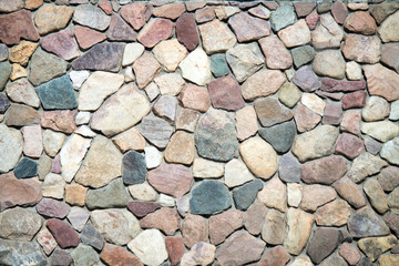 The wall is made of natural stone. Stone wall masonry is a natural material