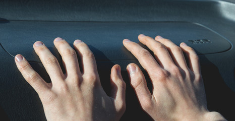 Hands on the airbag in the car salon