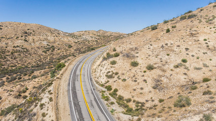 Bend in a desert road wrapping around a wilderness hillside.