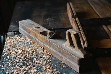Wood planer and shavings at carpenters workshop, old woodworking tool, sawdust. selective focus