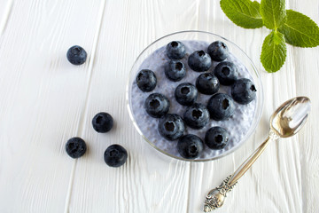 Pudding with chia  and  blueberries  on the white wooden background.Top view.