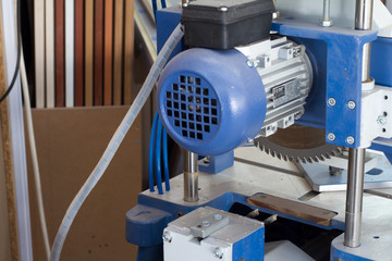 Industrial circular saw and vertical cutter in workshop.