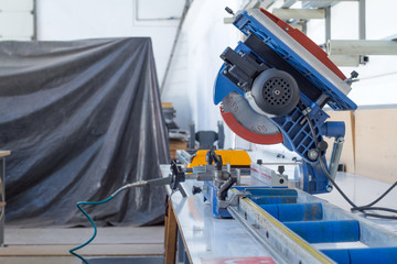 Industrial circular saw and vertical cutter in workshop.