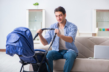 Young father looking after newborn baby at home