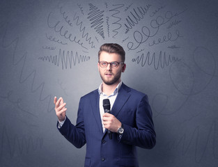 Businessman speaking into microphone with scribbles over his head 