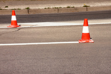 Work on road. Construction cones. Traffic cone, with white and orange stripes on asphalt. Street...