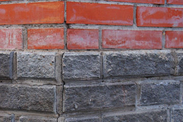 corner of a house made of red and gray bricks