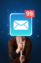 Casual young woman holding square sign with mail icon 