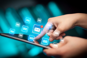 Female hands touching tablet with e-mail icons 