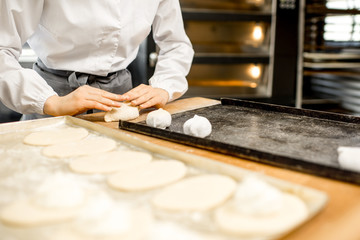 Workers forming raw buns with filling for baking at the manufacturing