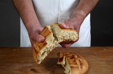 Breaking of a fresh loaf of Eucharistic bread 