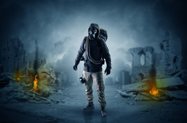 Destroyed place after a catastrophe with man in gas mask and weapon on his hand
