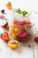 Infused water with peach, strawberry and cherry