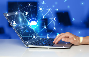 Hand using laptop with centralized cloud computing system and network security concept
