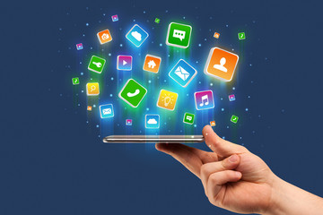 Businessman hand using phone with flying application icons around
