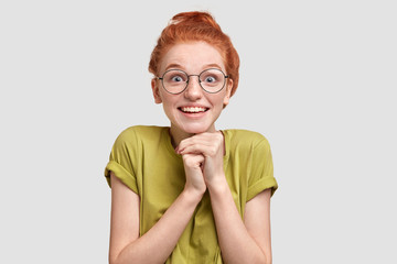 Portrait of amazed beautiful freckled female has overjoyed expression, doesn`t believe her eyes as...