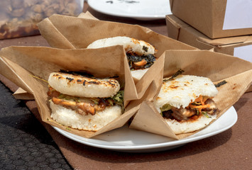 food samples, variations of diverse Asian burgers. The meat burgers served in the rice buns during...
