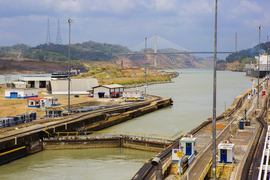 The Panama canal, exit from the first gateway. Ahead Of The Centennial Bridge. The picture shows the gateway barriers and utilities of the Panama canal. Ahead is seen the Centennial Bridge, which beca
