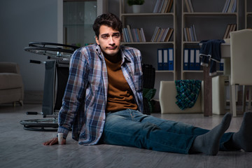 Fototapeta premium Man fell off wheelchair sitting on the floor