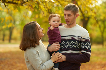 Fototapeta premium Cheerful family in an autumn park. Concept of rest and walk