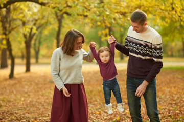 Fototapeta premium Cheerful family in an autumn park. Concept of rest and walk