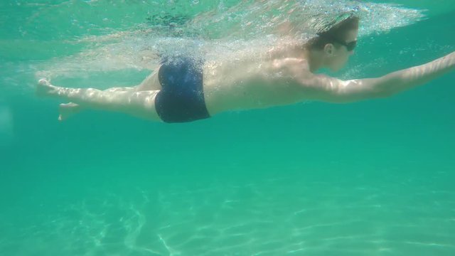 young man swim in the sea, raw, 4K