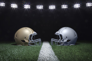 Football helmets facing off on a yard line below stadium lights at night
